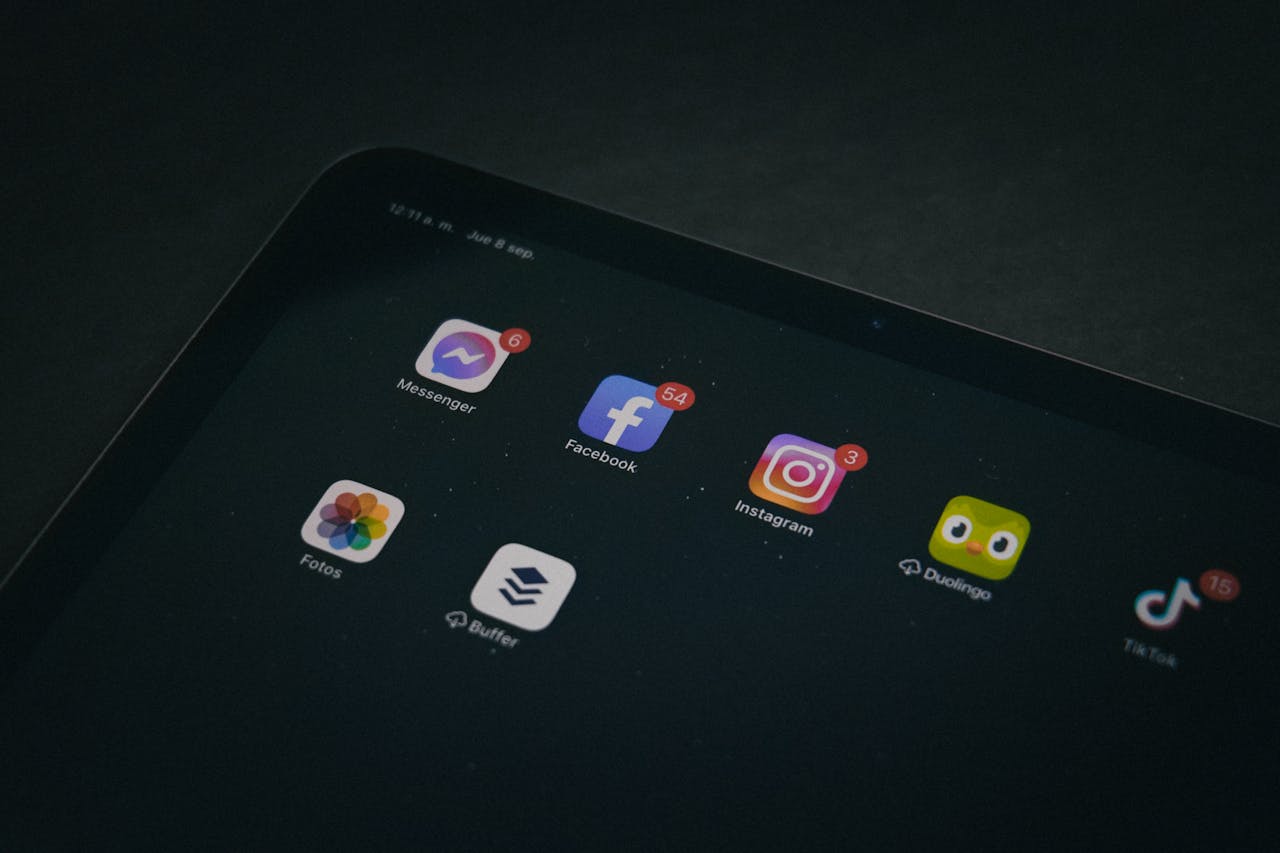 The Duolingo app icon among many other social media apps on an iPad screen.